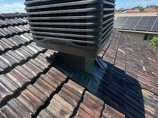 Evaporative air conditioning unit mounted on a tiled roof