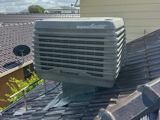 Roof-mounted evaporative cooling unit on a tiled roof