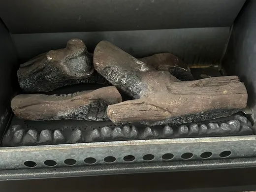 Gas log fireplace with ceramic logs connected and tested
