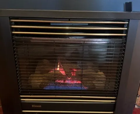 Gas log fireplace installed in a brick fireplace surround