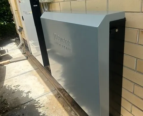 Whole-home water filtration system installed beside an external wall